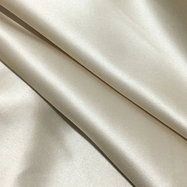 Dark grey silk pillowcase with envelope closure on a bed.