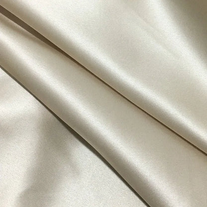Dark grey silk pillowcase with envelope closure on a bed.