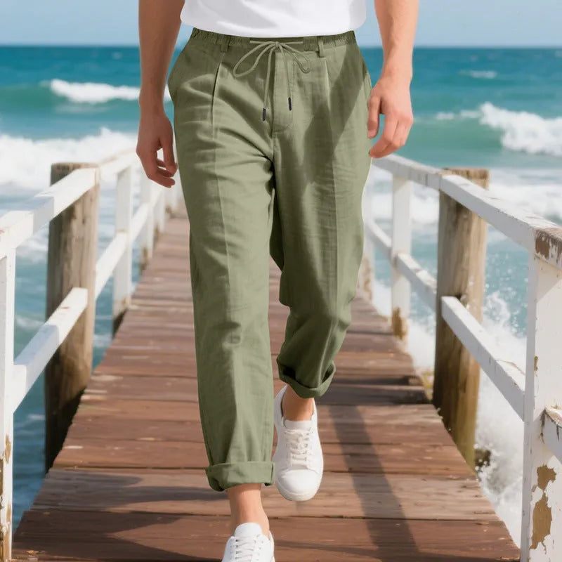 Men's light beige linen trousers with a loose straight leg and drawstring waist on a hanger.