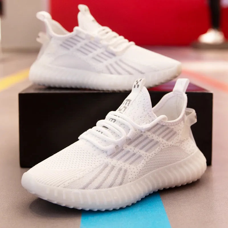 Men's low-top white mesh sneakers with a round toe and flat platform sole on a plain background.