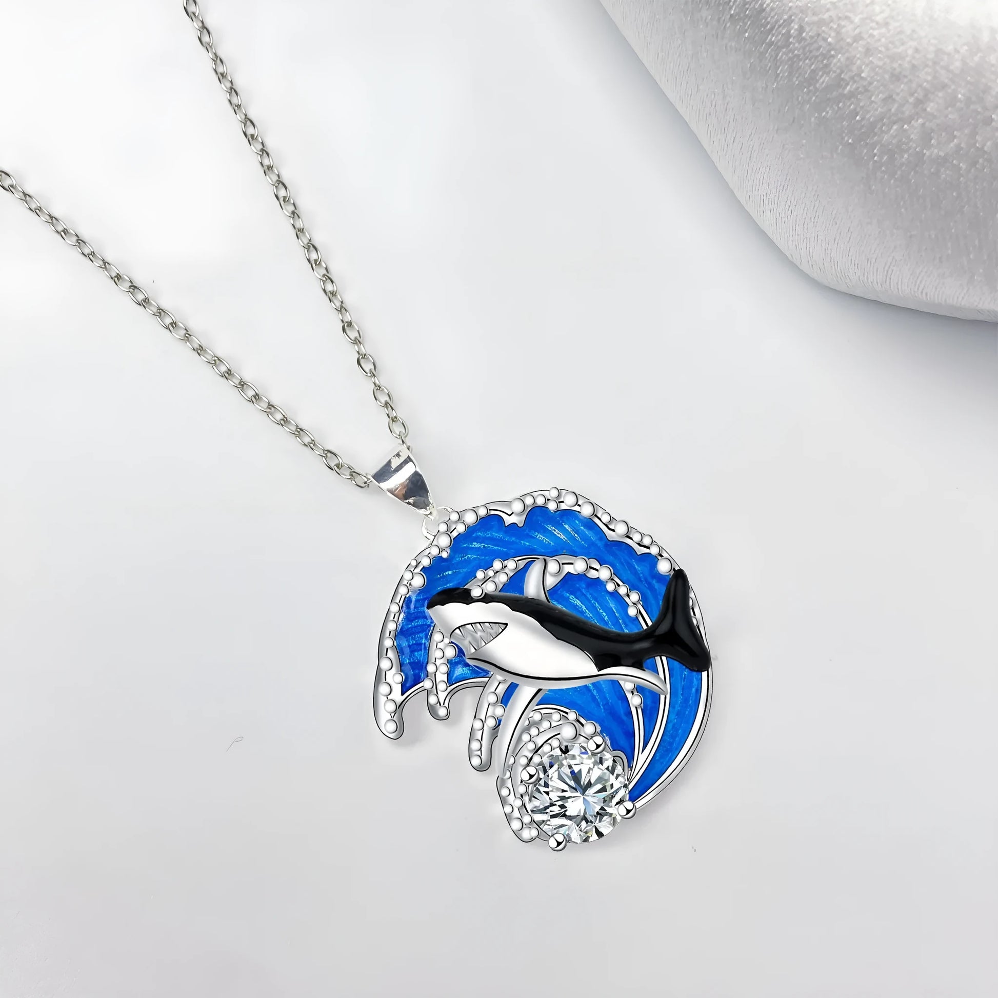 Close-up of a women's shark pendant necklace on a cross chain, showing detailed copper animal modelling.