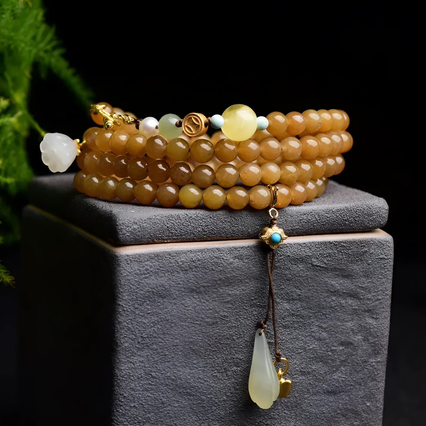 Women's bracelet with green pine beads, beeswax elements, leaf shapes, and sequin accents