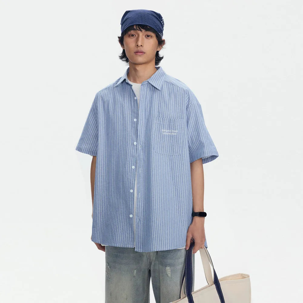 Blue and white striped loose-fitting short-sleeved overalls shirt on a hanger.