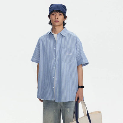 Blue and white striped loose-fitting short-sleeved overalls shirt on a hanger.