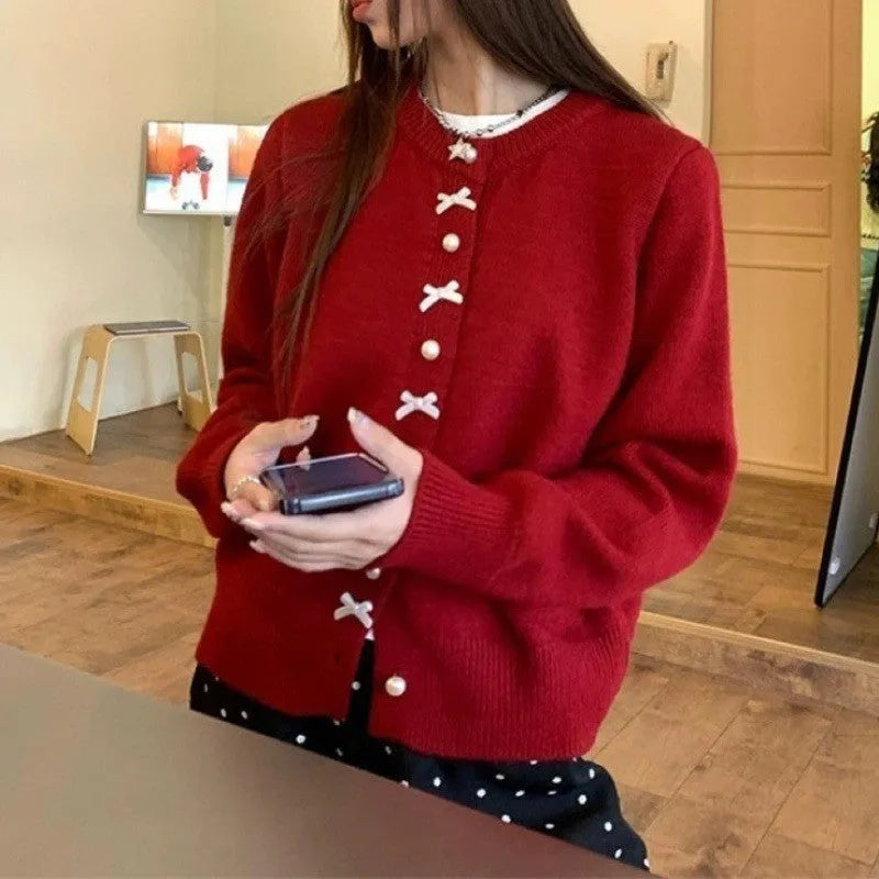 Women's solid colour cardigan sweater with bow pattern and pearl buttons in light blue.