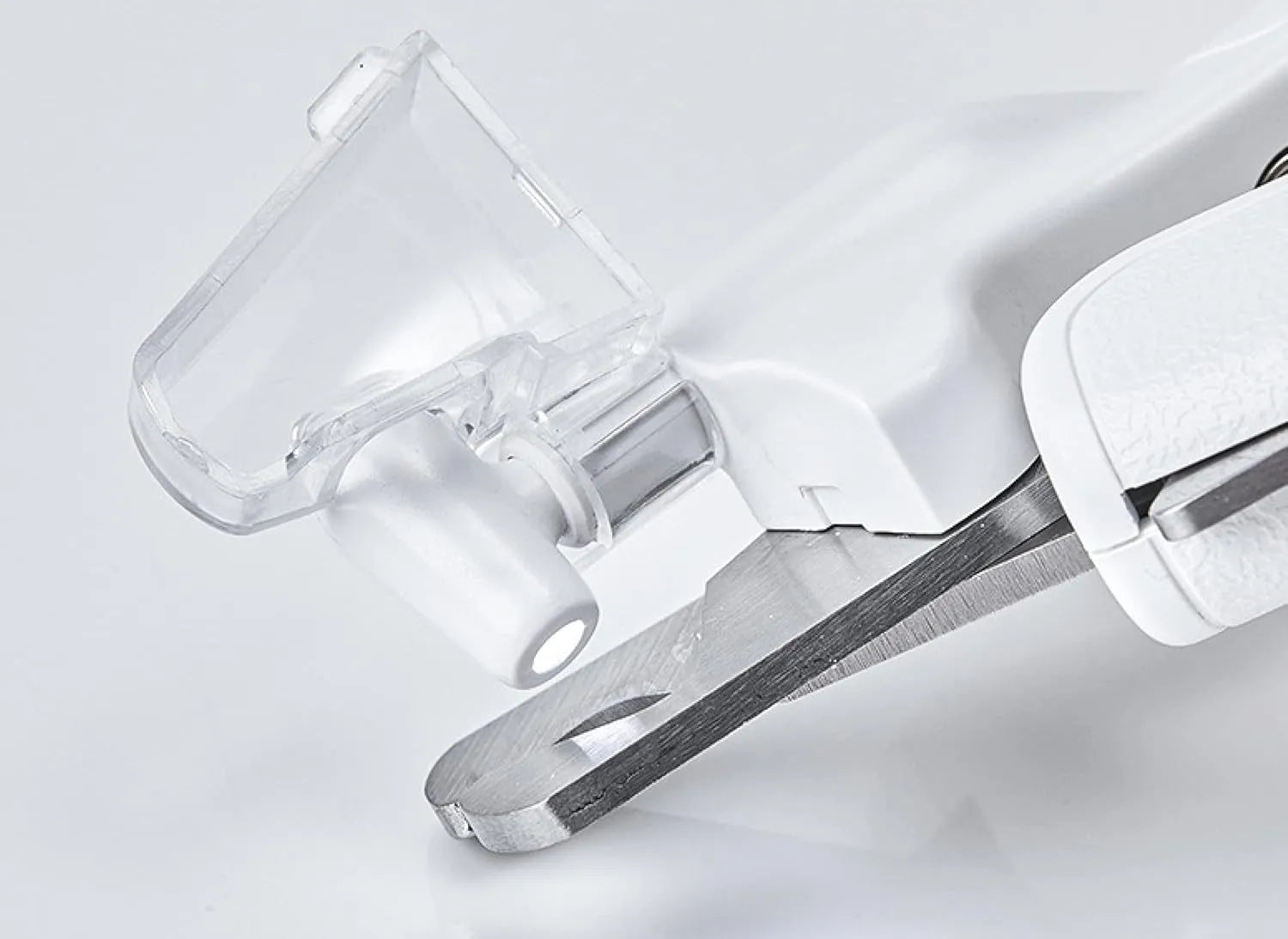 White pet nail clippers with LED light, anti-splash guard, and built-in nail file on a flat surface.