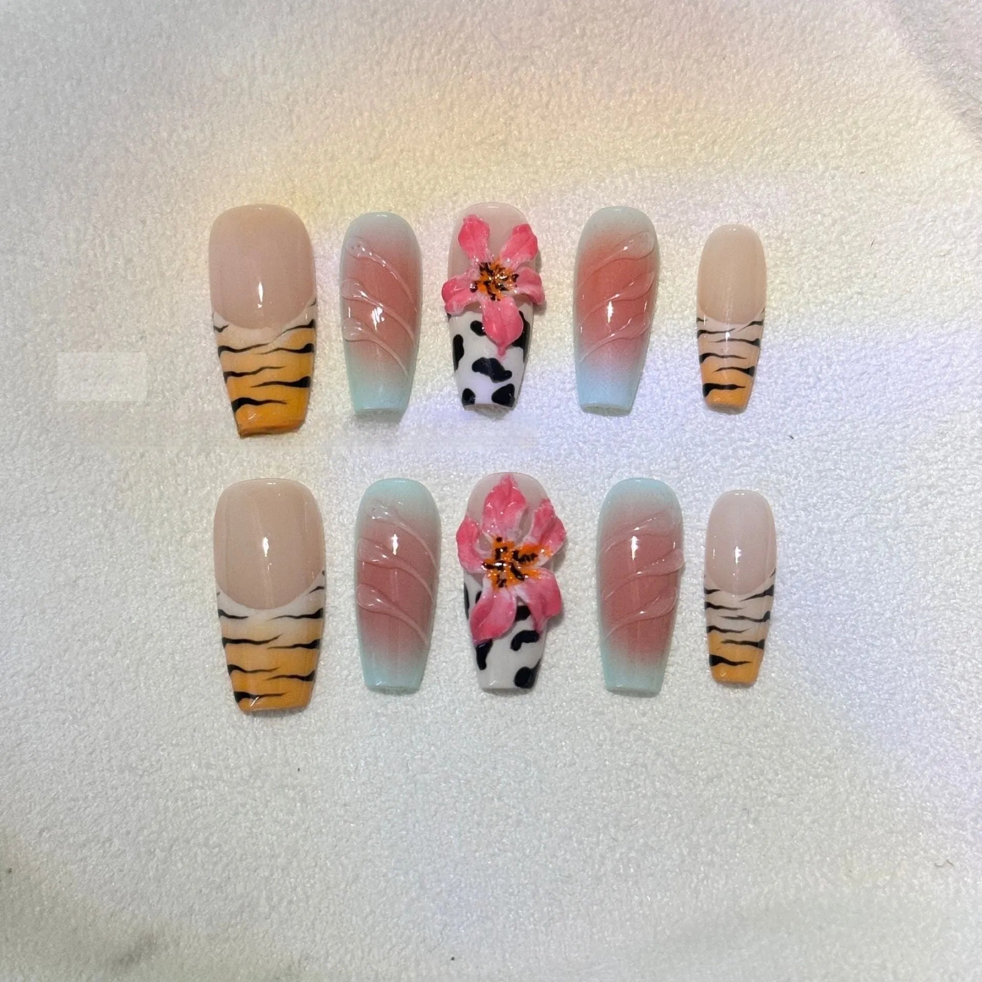 Hand-carved artificial nail art set with zebra pattern, embossed flowers, and leopard print in long length.