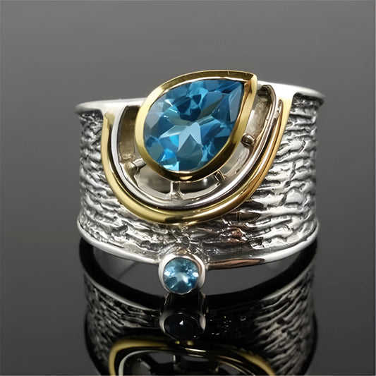 Drop-shaped women's ring with inlaid blue zircon stones on a model's hand, showing Chinese style details.