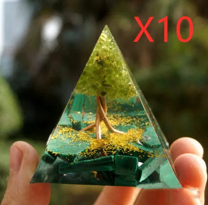 A small 6cm clear epoxy resin pyramid ornament containing pieces of natural crystal gravel on a flat surface.