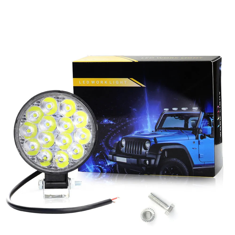 Small round white aluminium LED work light with IP67 rating for automotive use.