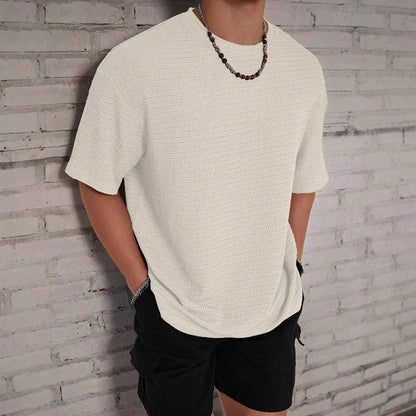Men's slim-fit solid colour short sleeve T-shirt on a hanger, showing lightweight fabric.