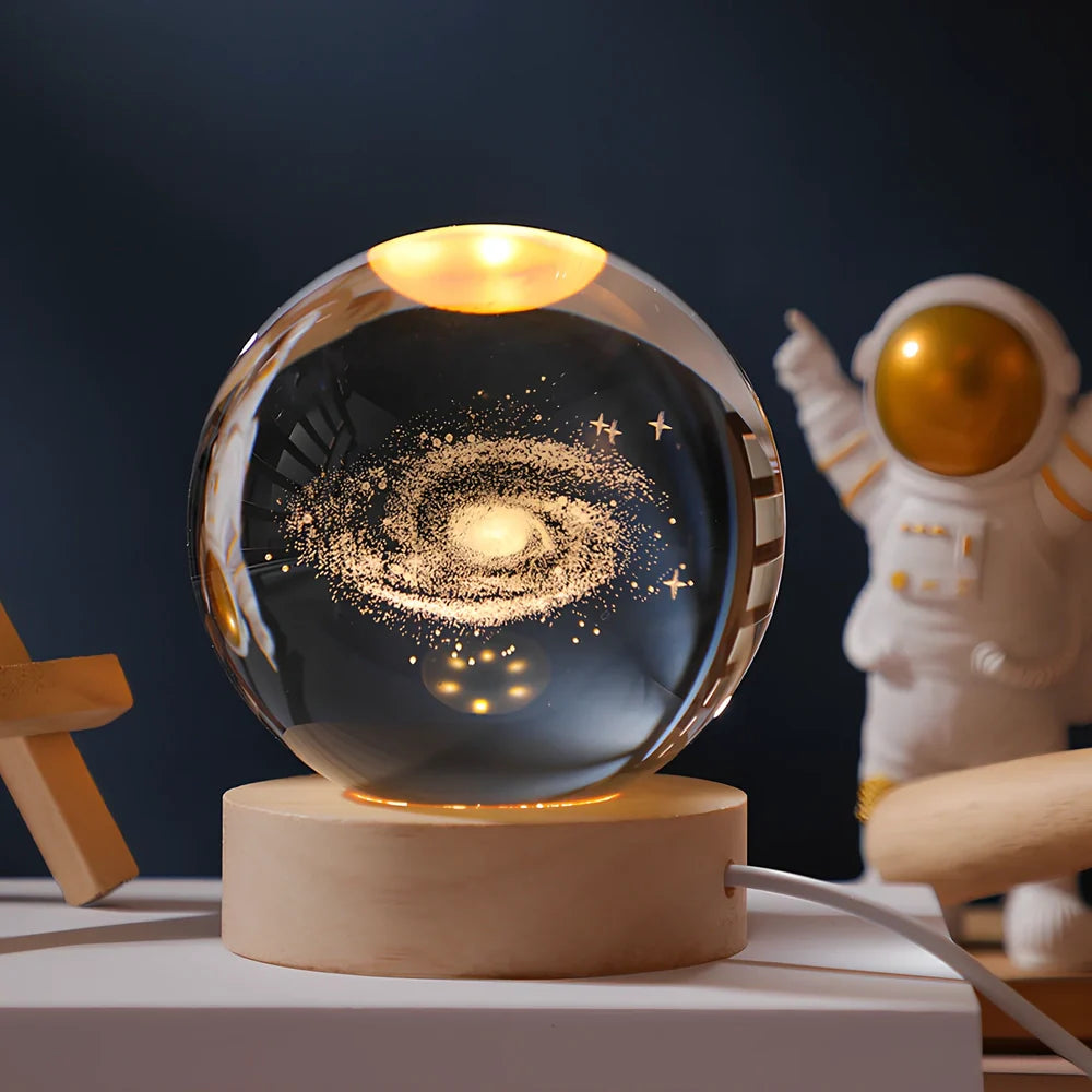 3D crystal ball night light projecting solar system pattern on wooden base with astronaut figurine