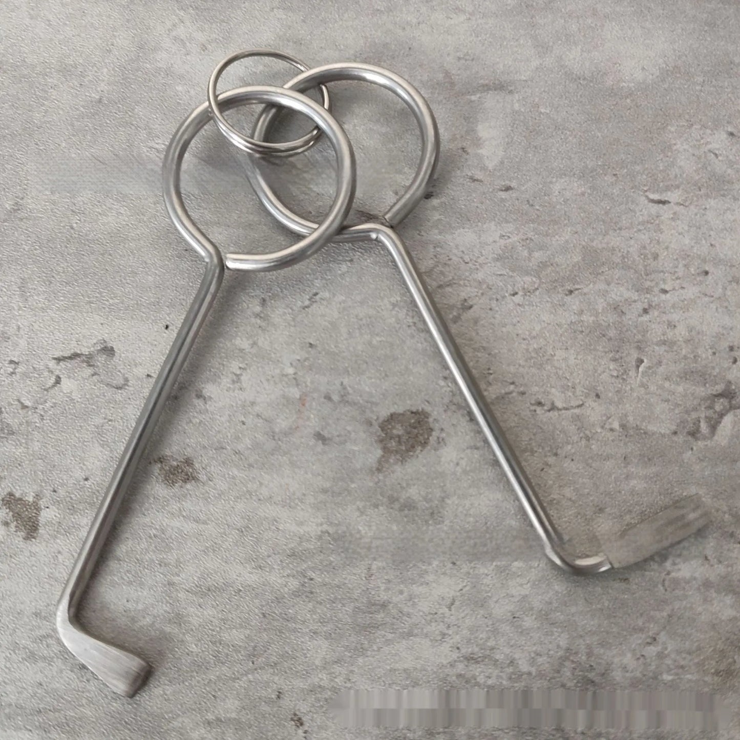 Two silver alloy wrench tools from a portable universal family set on a plain background.