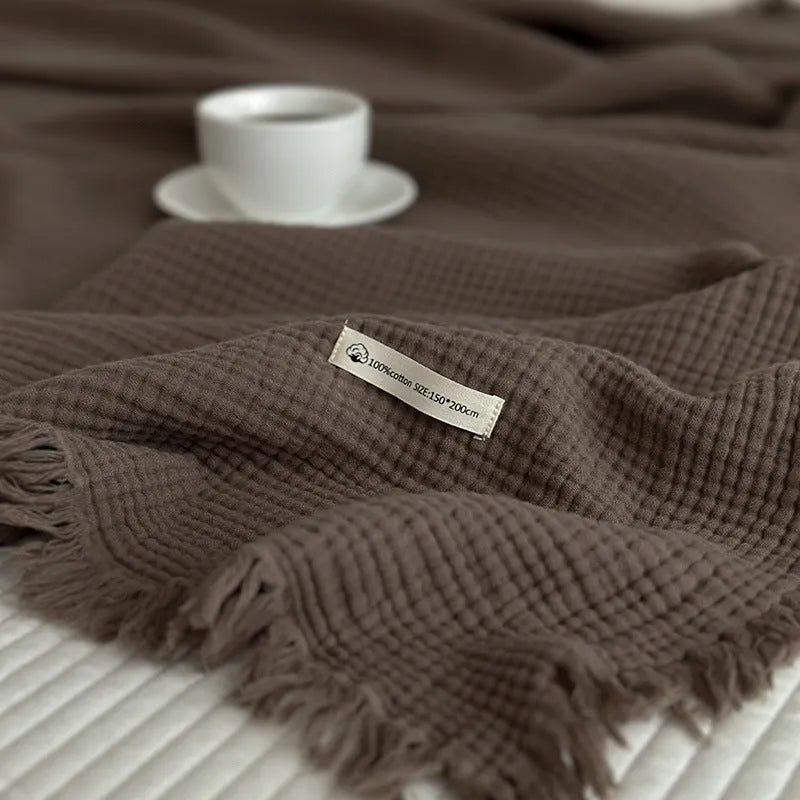 Four-layer gauze tassel blanket in cotton, showing tassel edges and textured fabric, available in multiple colours and sizes