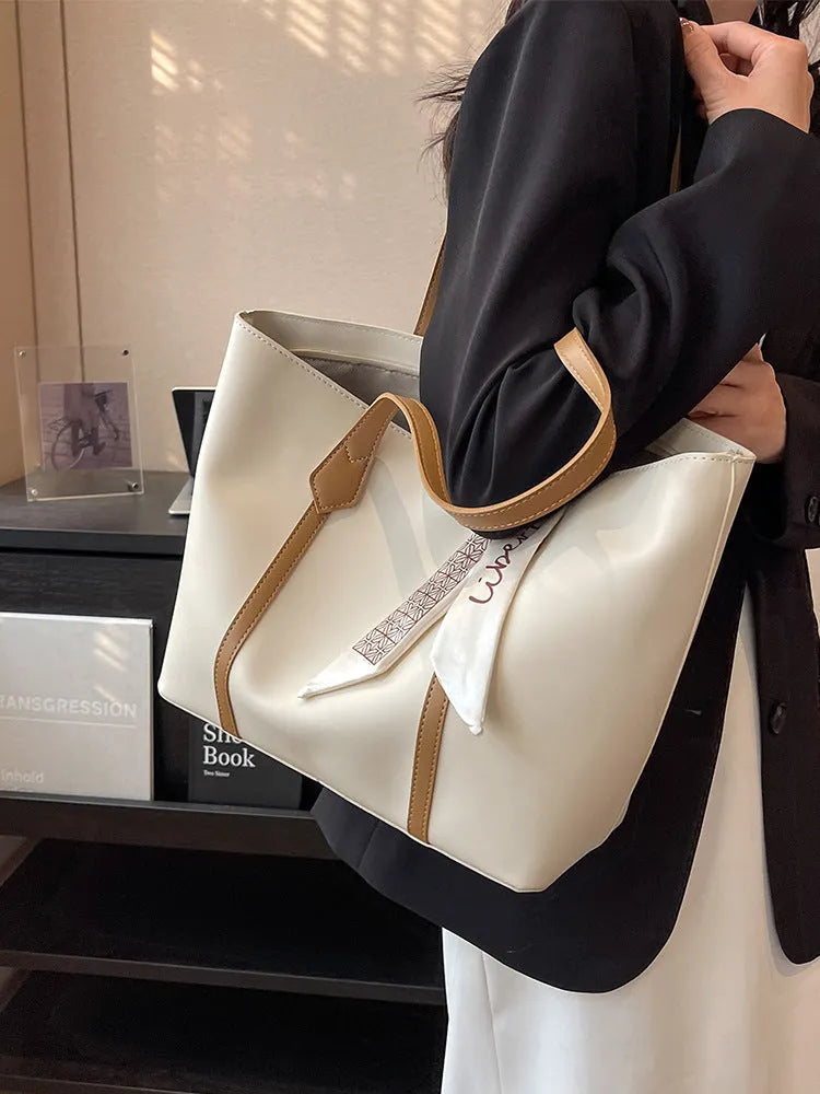 Soft large-capacity bucket tote bag with shoulder strap and zip pocket, shown in a neutral colour.
