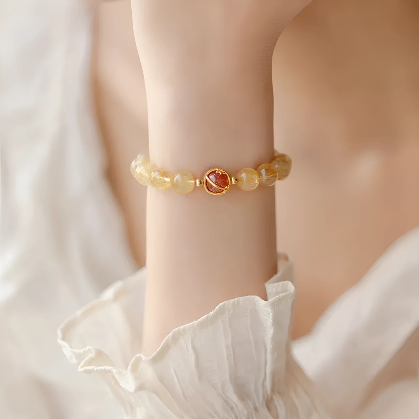 Citrine and gold rutilated quartz stretch bracelet with diamond-cut beads on an elastic band.