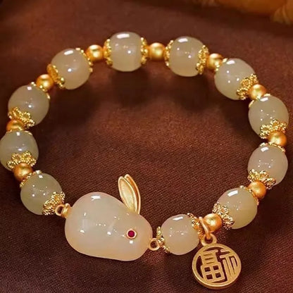 Green jade hare charm fu character bracelet with lily detail on black adjustable cord.