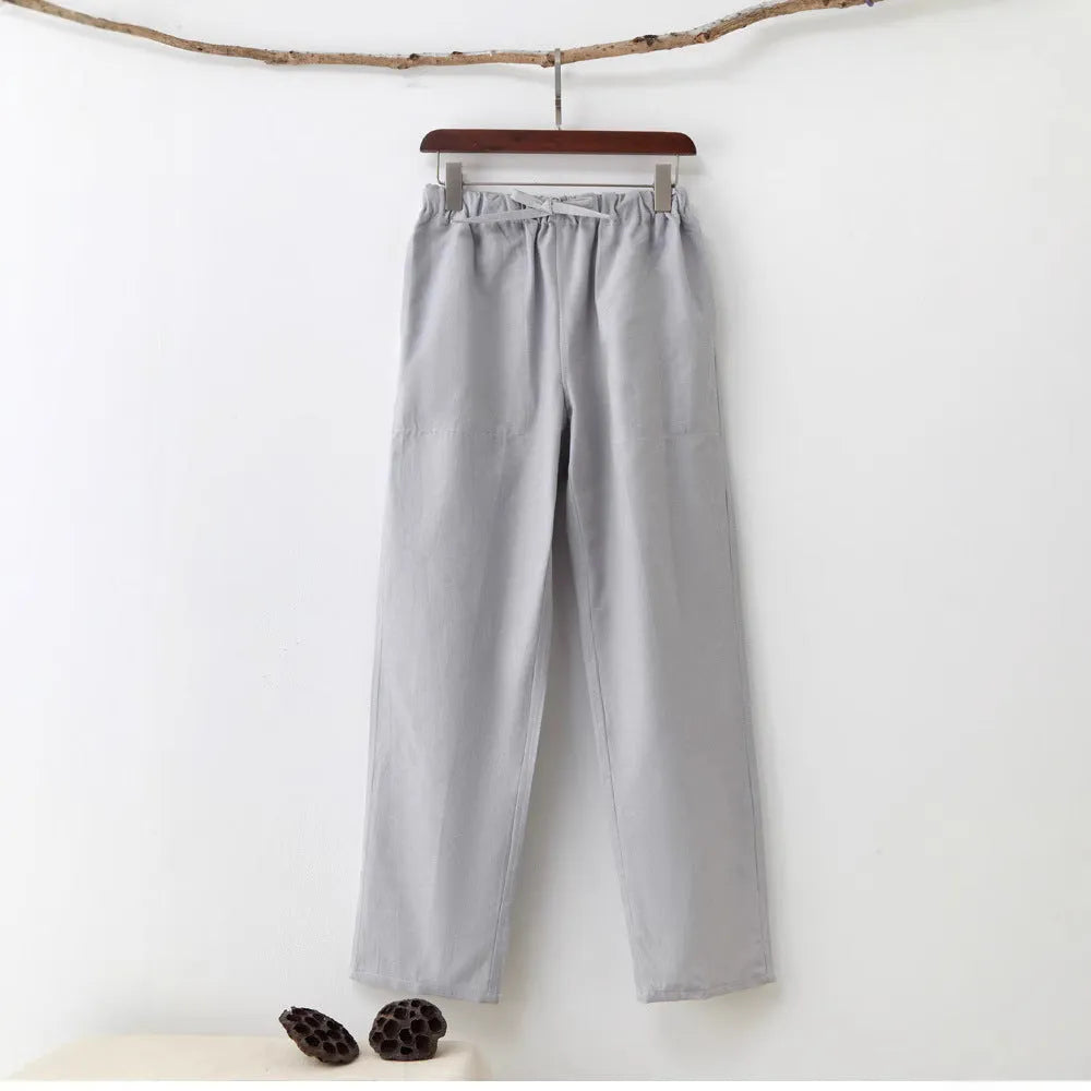 Men's beige pure cotton casual trousers with a drawstring waist on a mid-grey background.