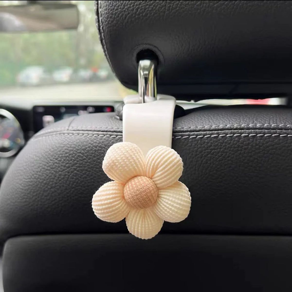 Khaki coloured plastic car seat hook with floral pattern for storage, shown at 11 by 5.5 cm.