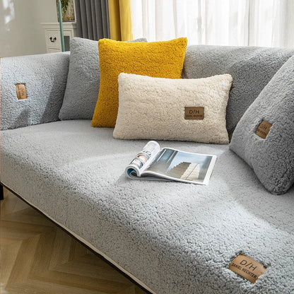 Beige lamb wool plush sofa cover with anti-slip backing on a grey fabric sofa.