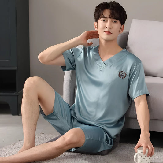 Man wearing a loose fit light blue ice silk short-sleeve pajama shirt and matching shorts.