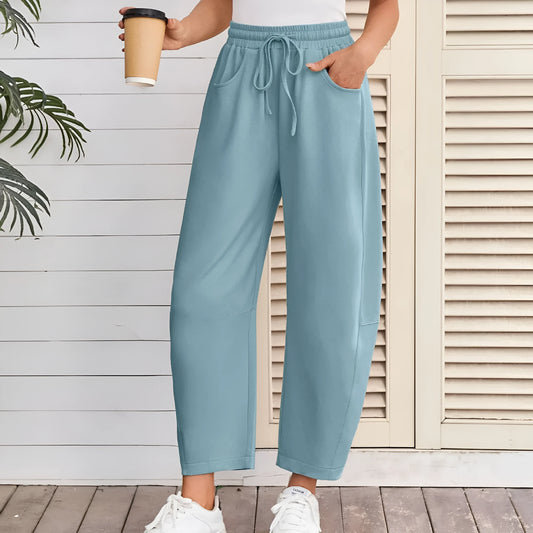 Loose-fit cropped sweatpants in army green with a drawstring waistband and side pockets on a neutral background