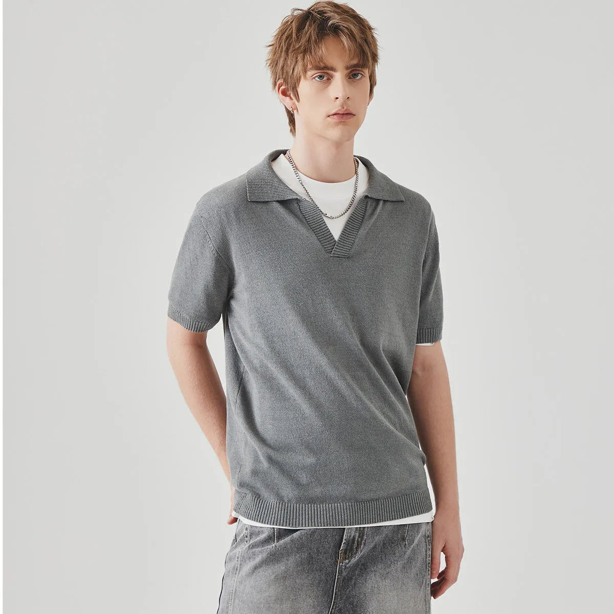 A man's solid-colour knitted polo t-shirt with short sleeves and a collar, shown in navy blue.