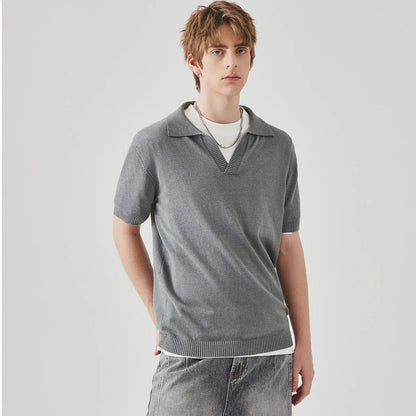 A man's solid-colour knitted polo t-shirt with short sleeves and a collar, shown in navy blue.