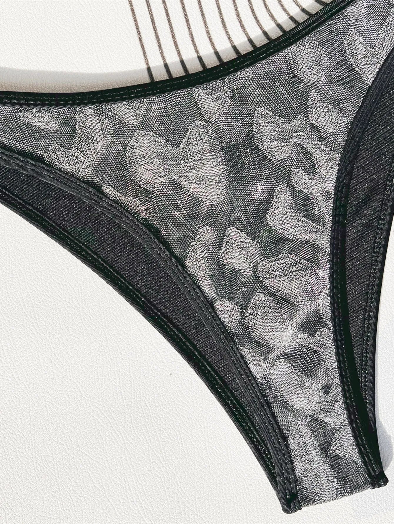 Women's black polyester bikini swimsuit with adjustable straps laid flat