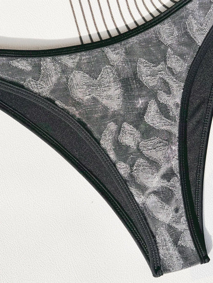 Women's black polyester bikini swimsuit with adjustable straps laid flat