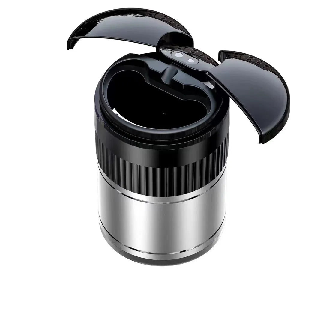 Compact black metal car ashtray with automatic lid on a car console