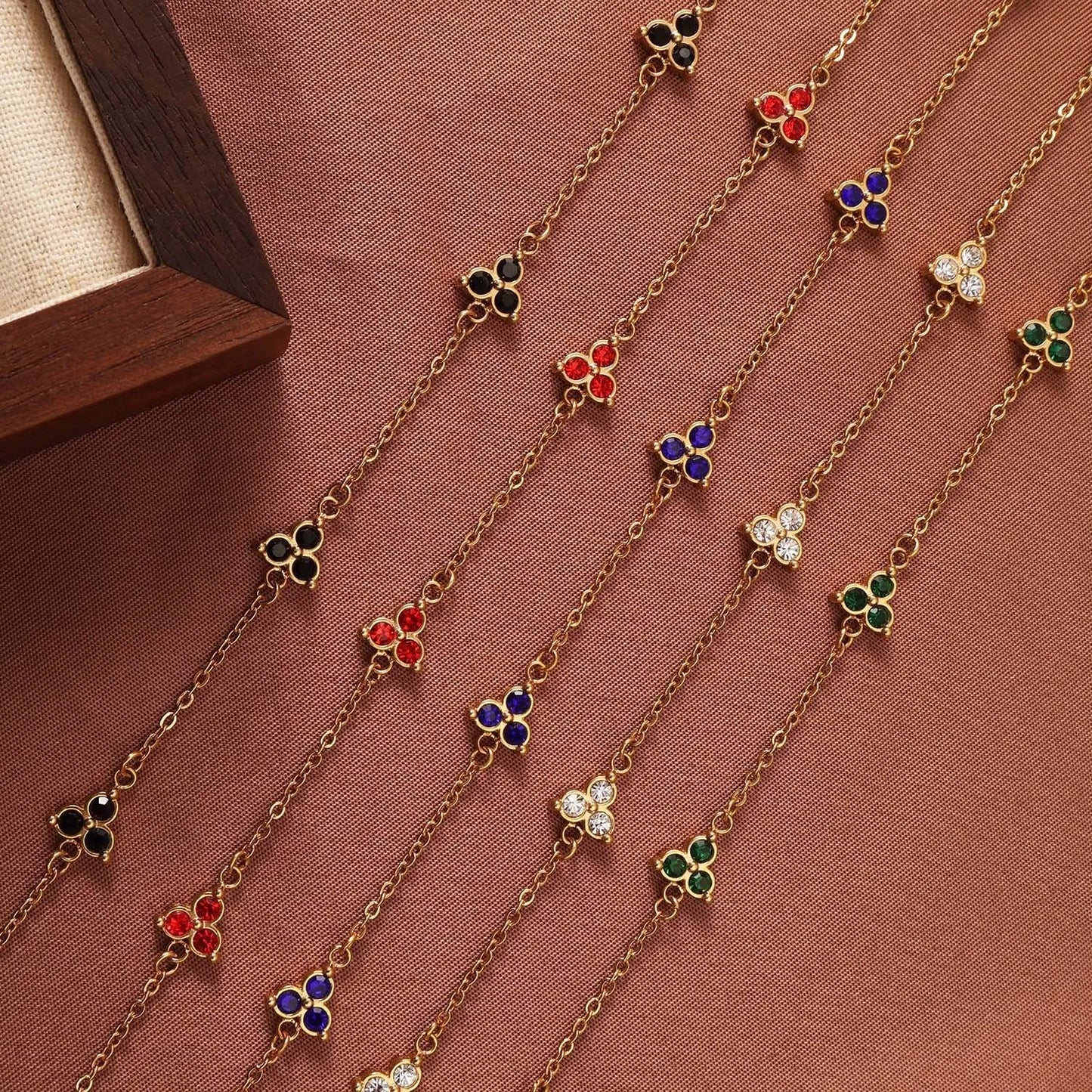 Women's stainless steel bracelet with three triangle-shaped charms in different coloured stone settings