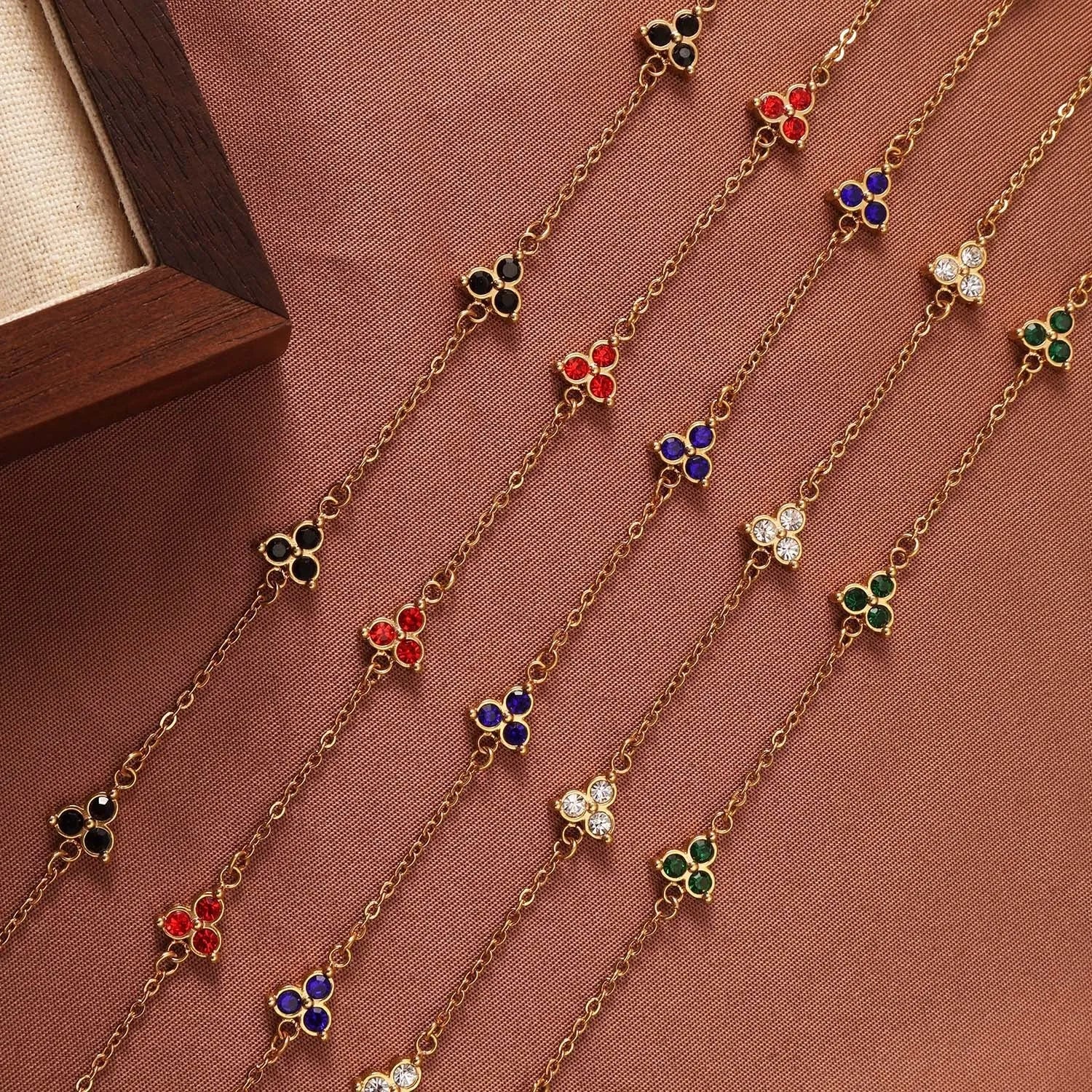 Women's stainless steel bracelet with three triangle-shaped charms in different coloured stone settings