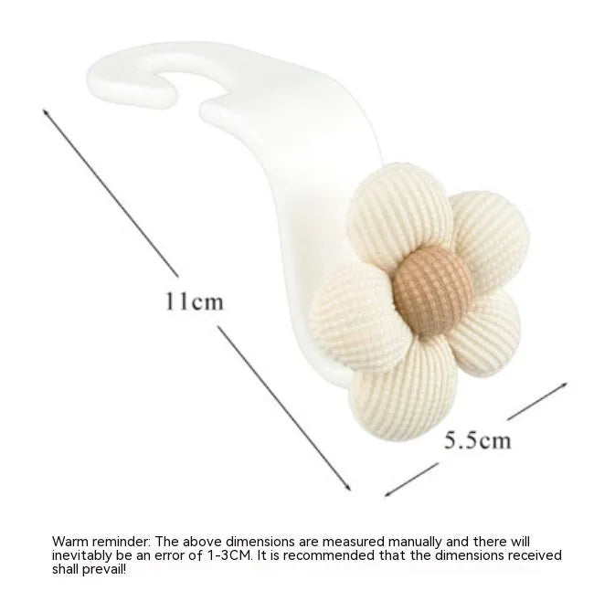 Khaki coloured plastic car seat hook with floral pattern for storage, shown at 11 by 5.5 cm.