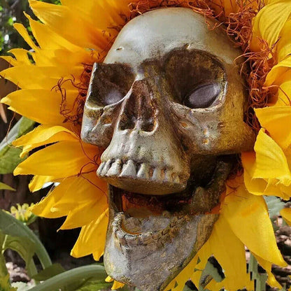 A group of skull-shaped sunflower ornaments arranged in a Halloween-themed outdoor display