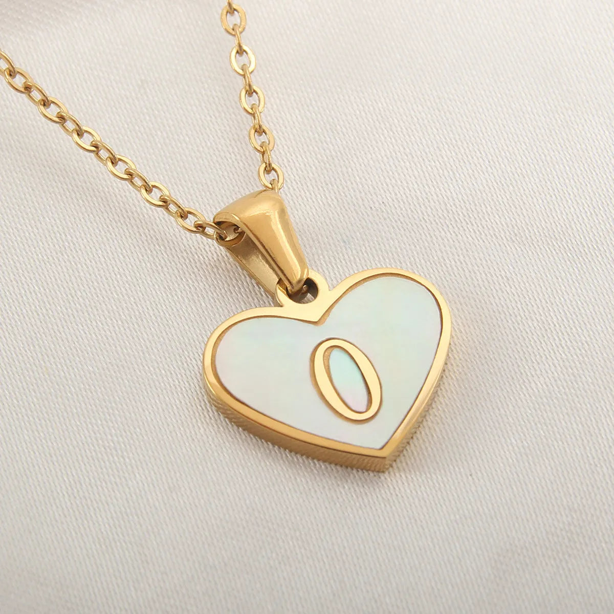 Gold-plated clavicle necklace with a white shell heart pendant, personalised with a letter from A to Z.