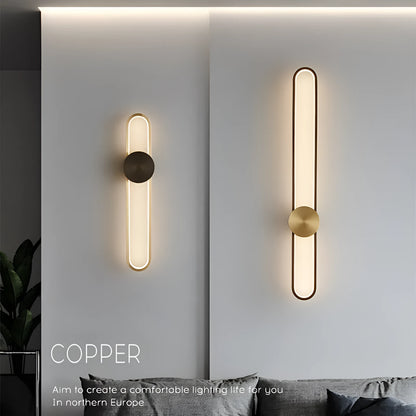 Round black iron wall sconce with integrated LED light glowing on a modern grey wall