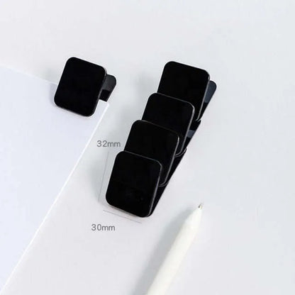 Square plastic photo holder in black, white, and transparent colour options on desk