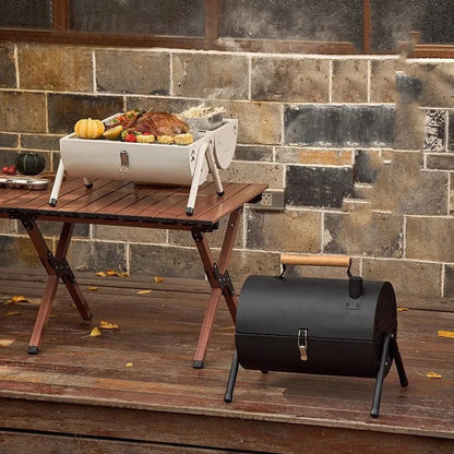 White round portable grill with chimney oven, carbon tanks, and grilled meshes for frying and baking outdoors.