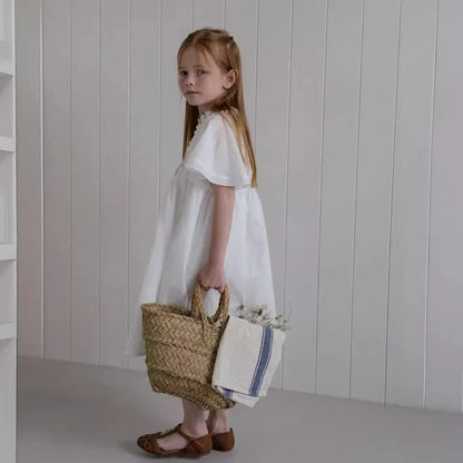 White cotton girls dress with embroidered skirt detail, short sleeves, and Western style silhouette