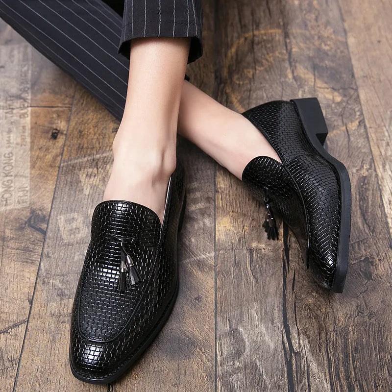Men's black pointed toe slip on shoe with a decorative tassel on the artificial PU upper.