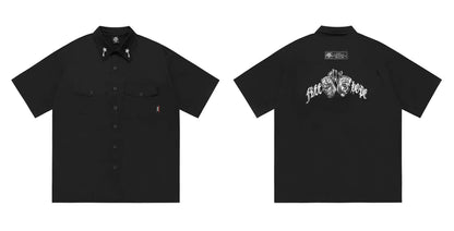 Man wearing a black cotton blend half-sleeve loose fit work shirt with embroidered detail.