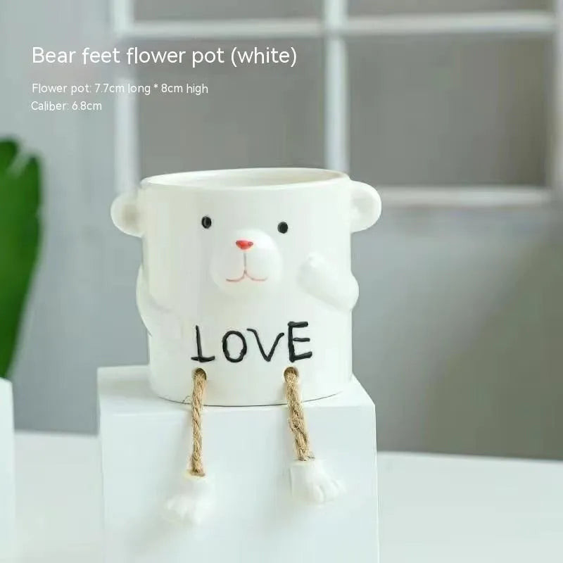 Ceramic hanging foot flowerpot for succulent plants with cartoon styling on desktop