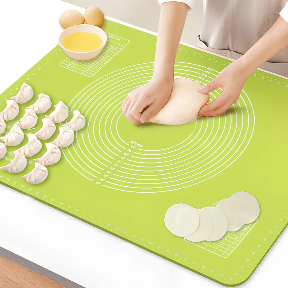 Green antibacterial silicone kneading mat with noodle cutter and rolling pin on kitchen counter