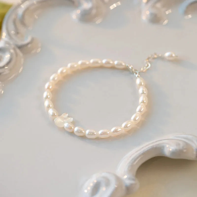 White pearl bead bracelet with silver rabbit charm on elastic string