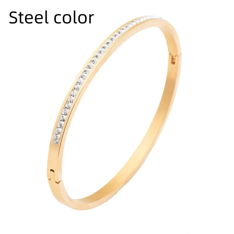 Elegant stainless steel bracelet with diamond accent, available in gold, rose gold, and steel finishes.