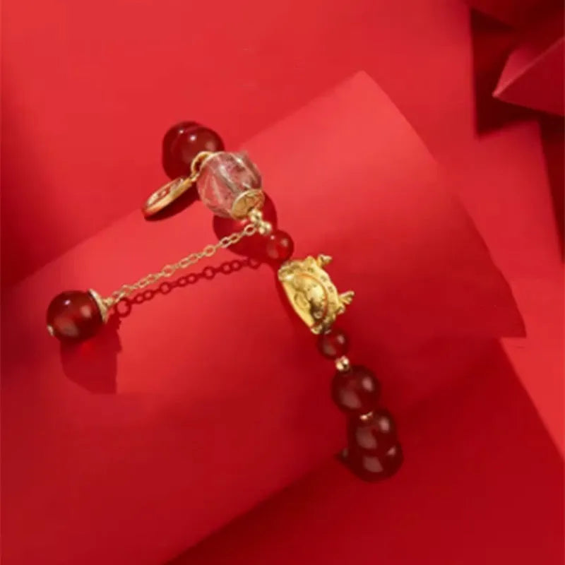 Women's Chinese style bracelet with Hetian jade, red agate beads, and a dragon design on gold and silver.