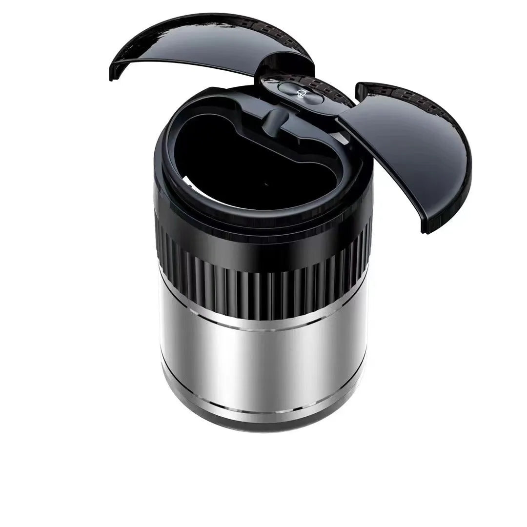 Compact black metal car ashtray with automatic lid on a car console
