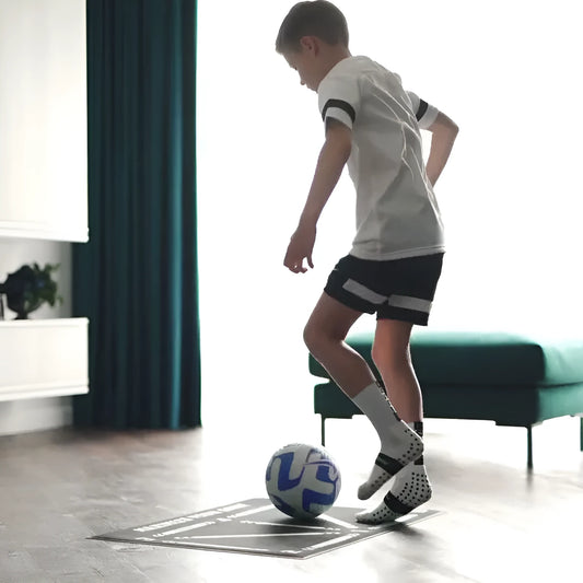 Black 60x90cm non-slip football training mat laid flat on a floor.