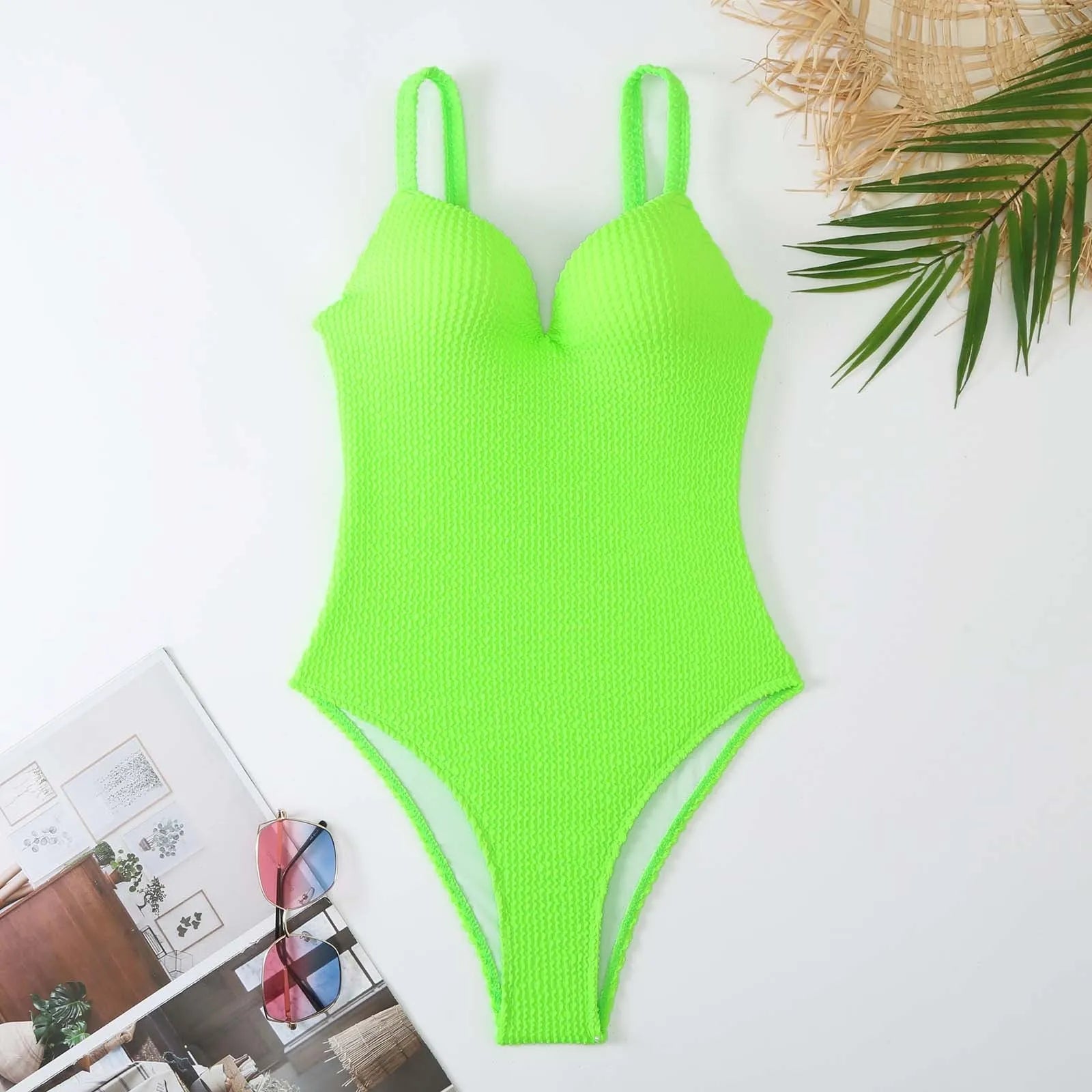 Women's black one-piece swimsuit with a sunken vertical stripe detail, shown on a model, featuring a sleeveless design.
